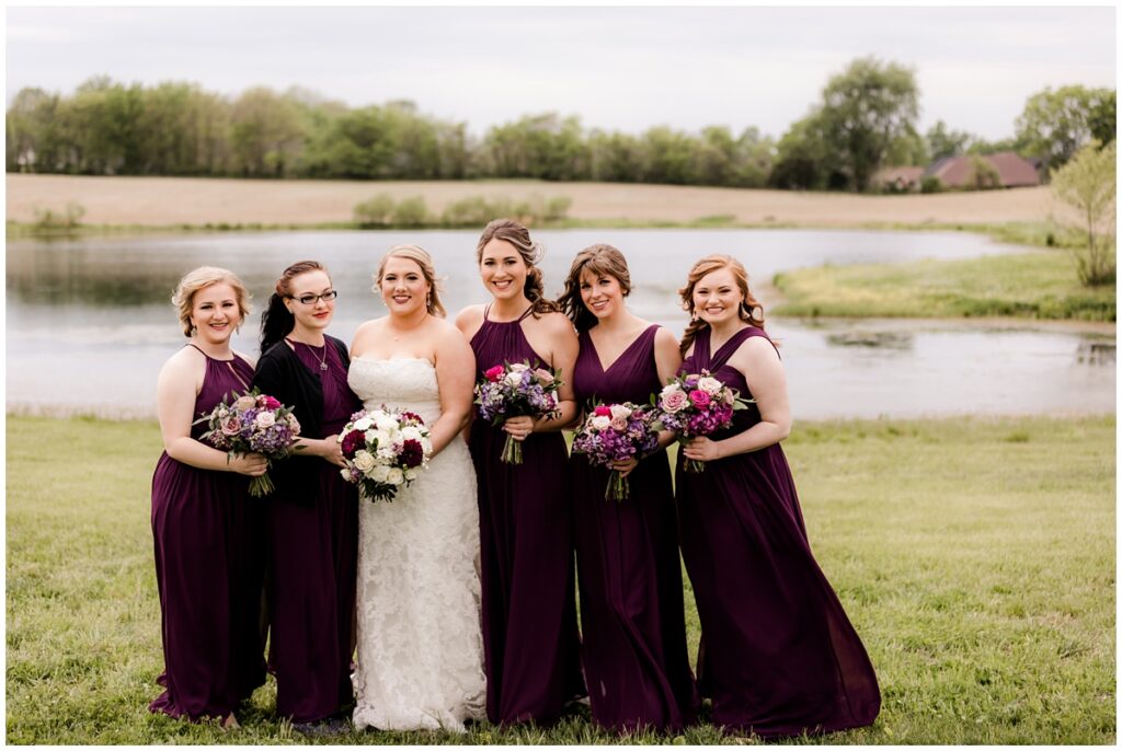 Bride and her bridesmaids wearing fall burgundy dresses during bridal portraits at the Ruby Cora Wedding venue in nashville, Tennessee
